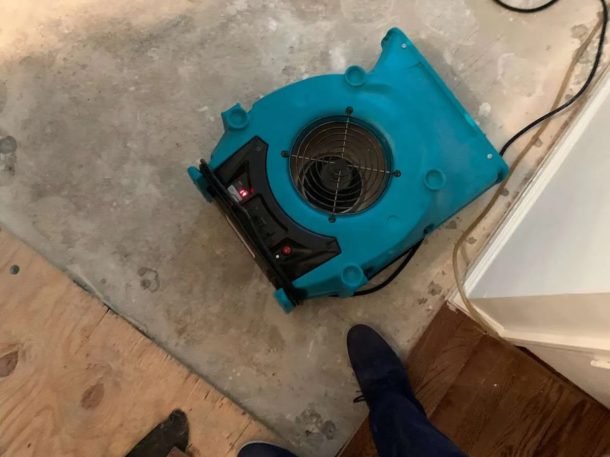 Air mover drying subfloor during Commercial Water Damage Restoration in Babylon